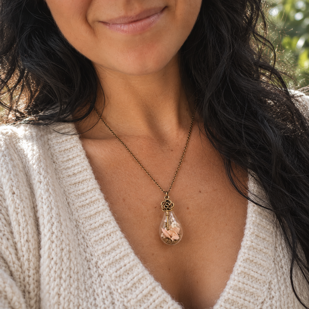 Pendentif floral personnalisé porté au cou avec fleurs naturelles dans un globe en verre