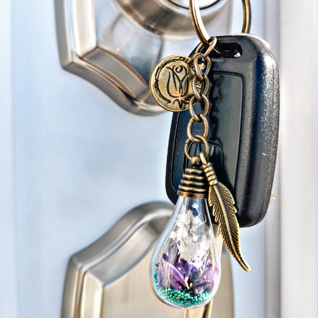 Porte-clé ampoule avec fleurs mauves et breloque plume – accessoire symbolique Créations Odrey