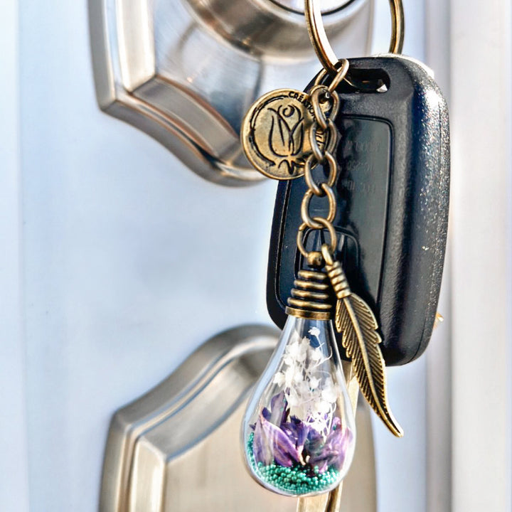 Porte-clé ampoule avec fleurs mauves et breloque plume – accessoire symbolique Créations Odrey