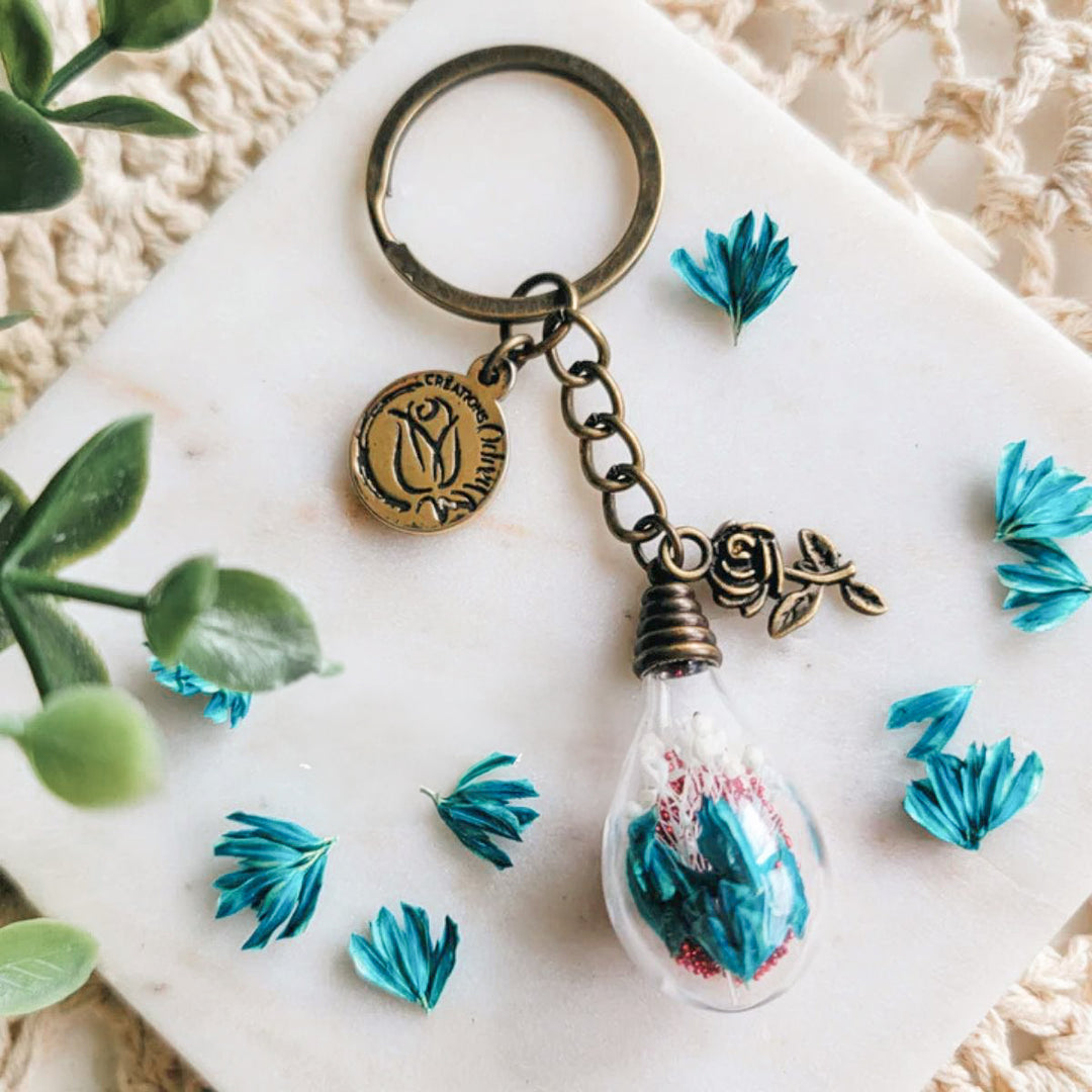 Accessoire floral fait main avec fleurs bleues et rose bronze – parfait petit cadeau à offrir pour un événement marquant