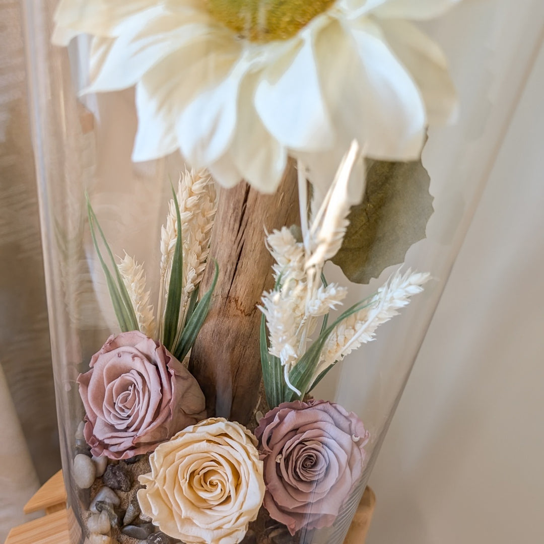 Arrangement floral avec roses éternelles marron et tournesol dans un grand vase cylindrique