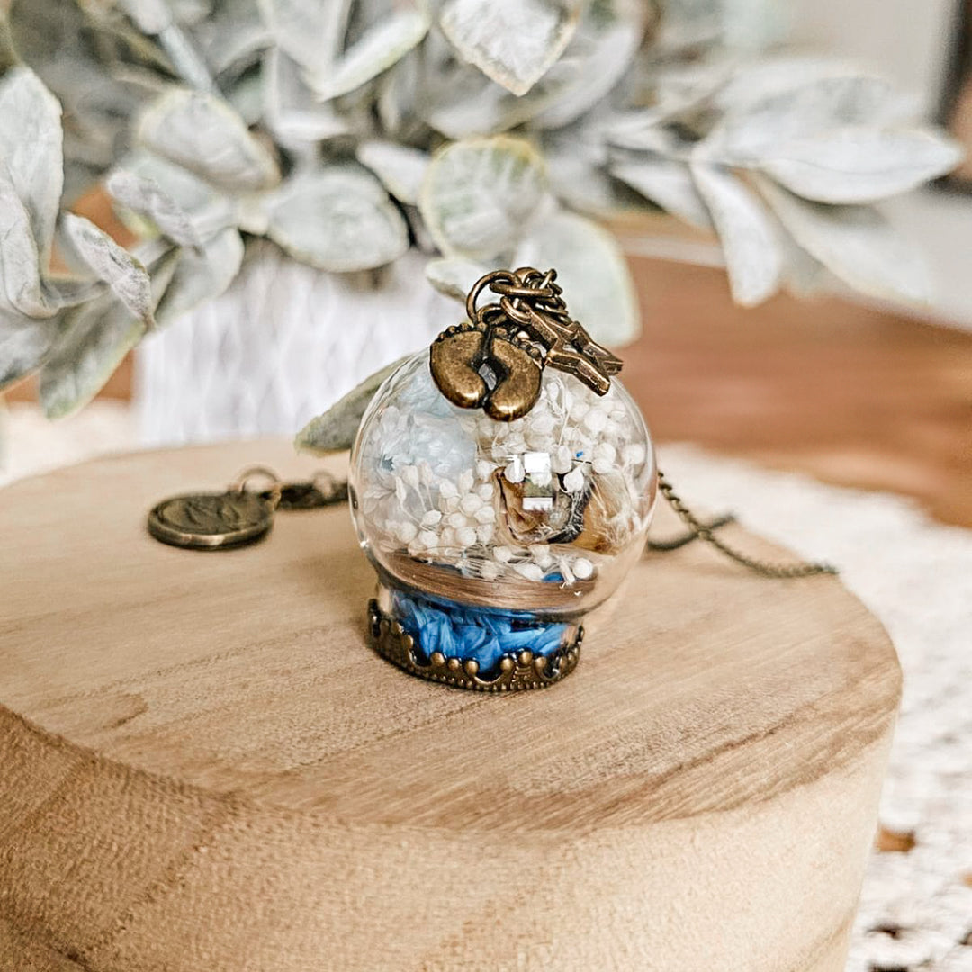 Bijou souvenir de deuil périnatal avec cordon ombilical et fleurs séchées, création artisanale.