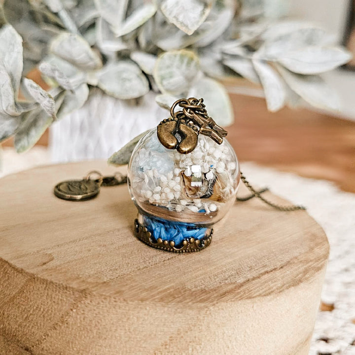Bijou souvenir de deuil périnatal avec cordon ombilical et fleurs séchées, création artisanale.