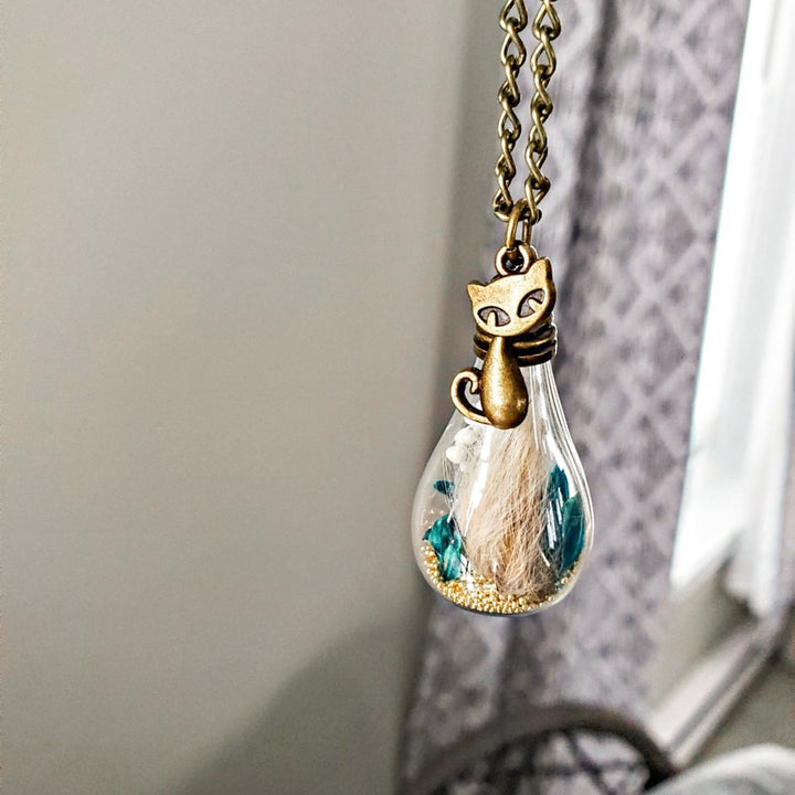 Médaillon souvenir chat décédé avec poils en goutte de verre, fleurs séchées turquoise et breloque chat bronze artisanal Québec