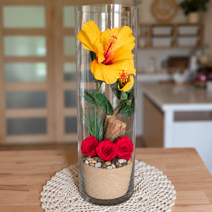 Décoration florale pour la maison avec hibiscus jaune et roses éternelles rouges dans un grand vase en verre