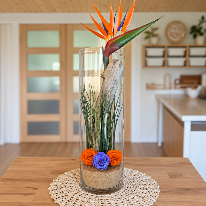 Décoration florale avec oiseau du paradis et roses éternelles orange et violette dans un grand vase cylindrique