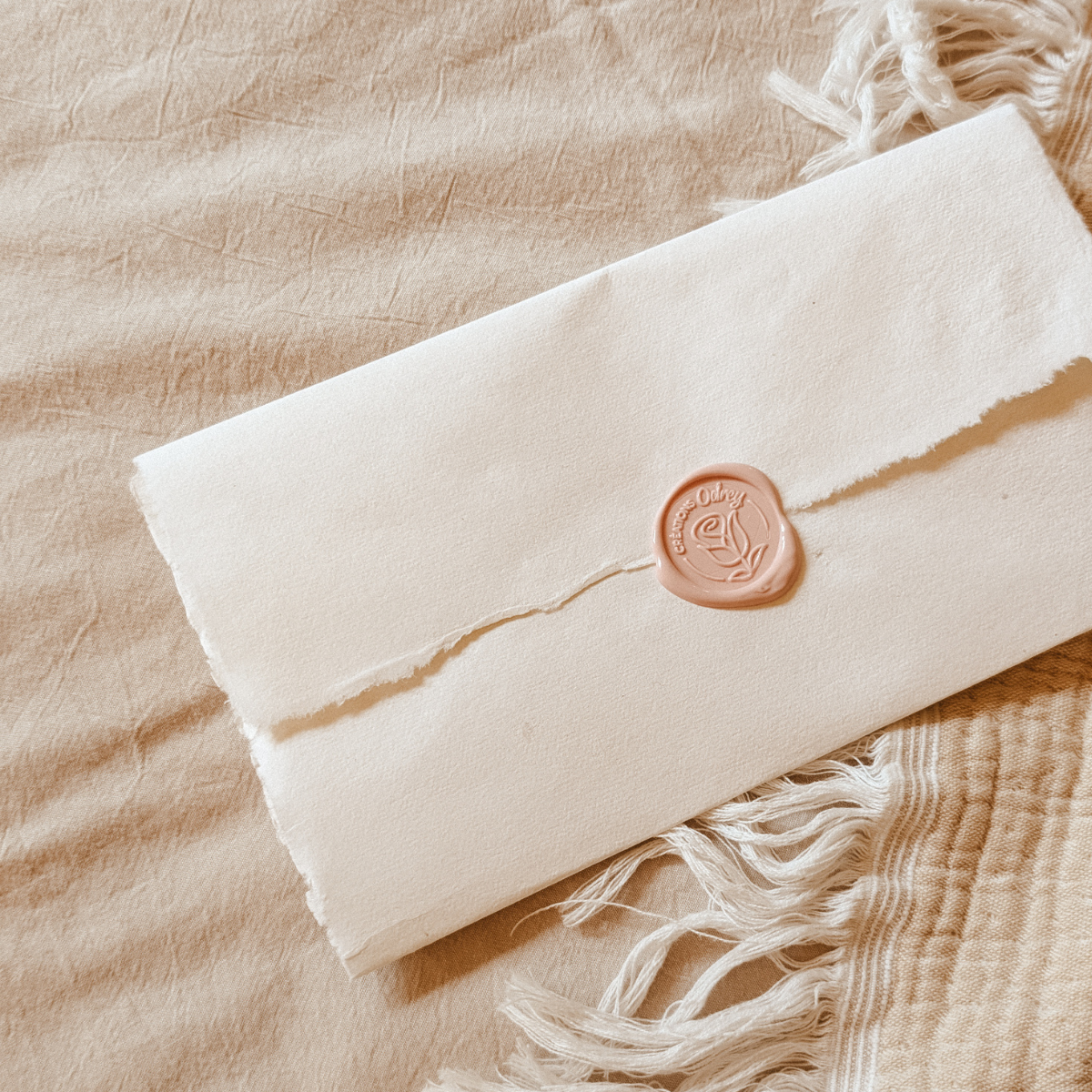 Lettre symbolique scellée à la cire avec le logo Créations Odrey, sur un lin naturel