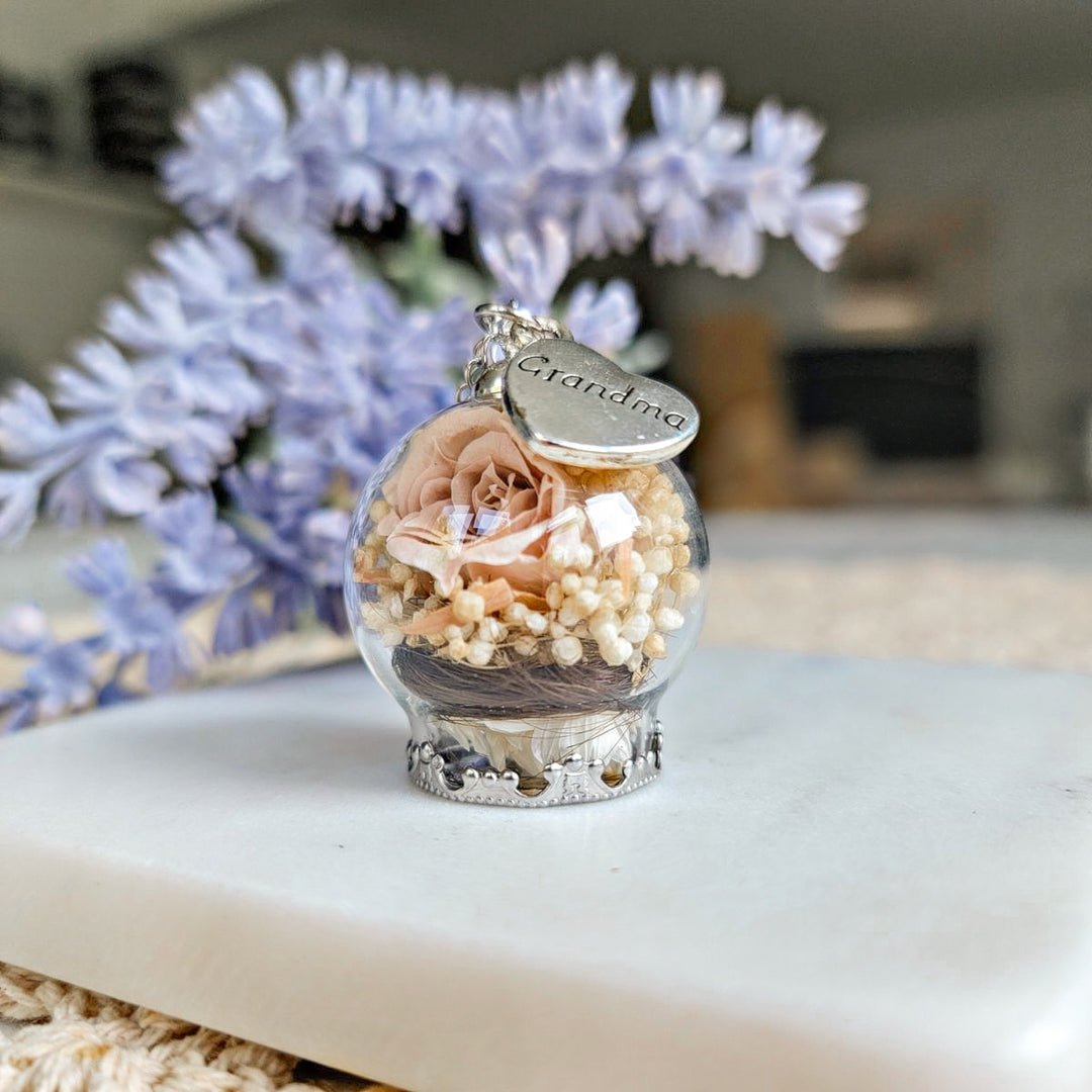 Pendentif souvenir avec mèche de cheveux visible sous un globe de verre, rose nude et breloque Grandma, fait main au Québec