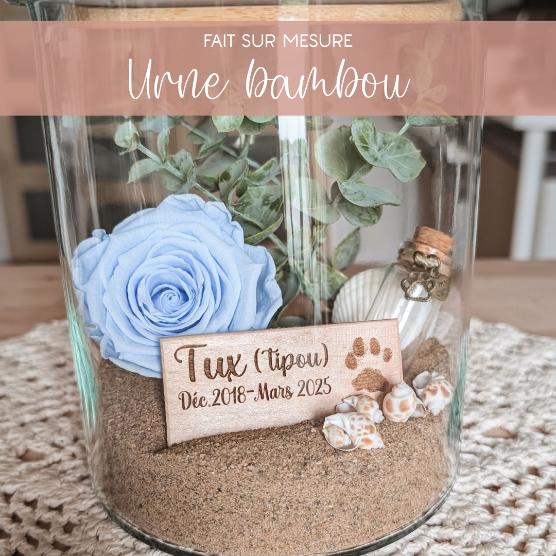 Arrangement floral de deuil animalier avec rose éternelle bleue et plaquette de bois gravée, création artisanale empreinte de douceur et de souvenir.