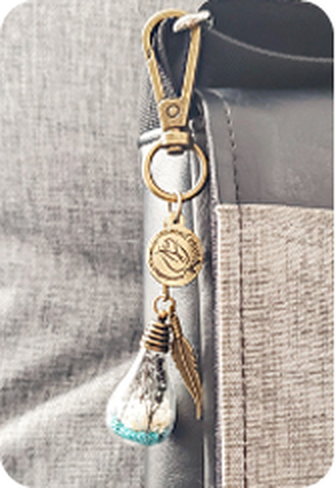 Pendentif souvenir accroché à un mousqueton sur un sac