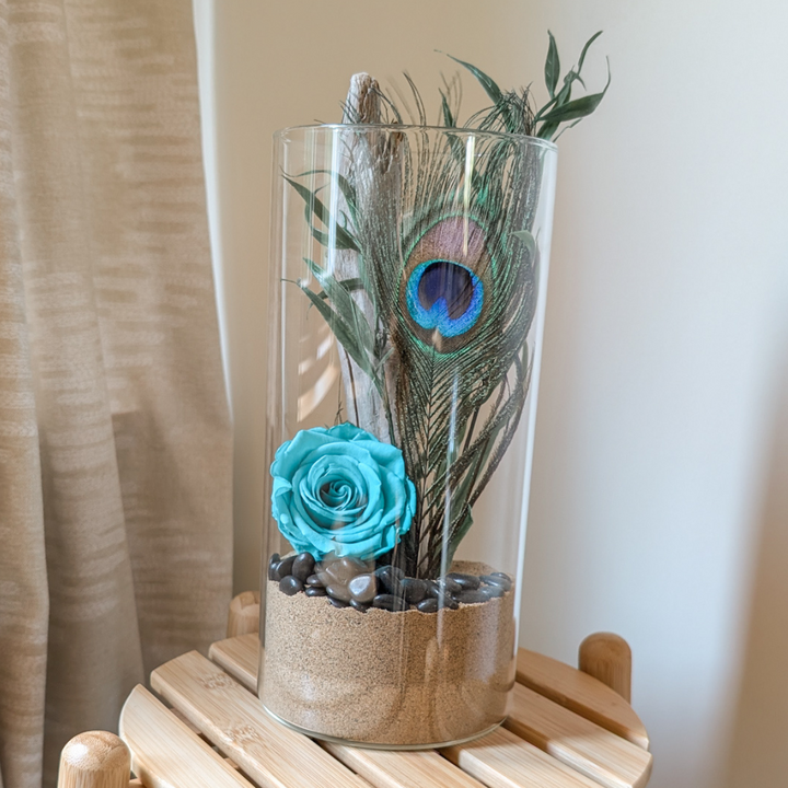 Vase décoratif fleuri, création artisanale avec plume de paon et rose éternelle turquoise.