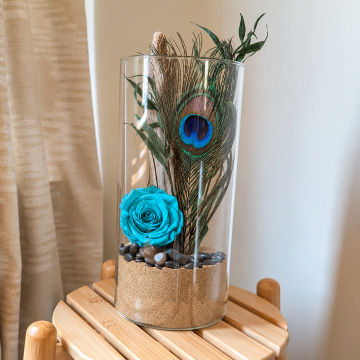 Vase décoratif fleuri, création artisanale avec plume de paon et rose éternelle turquoise.