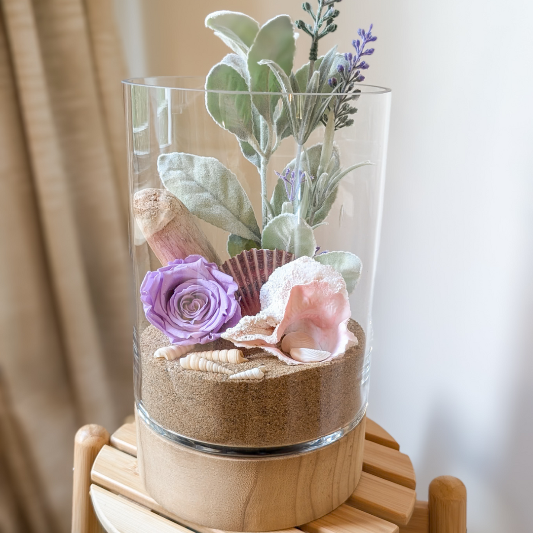 Vase floral nature avec fleurs de lavandes et sable doré, style bord de mer.